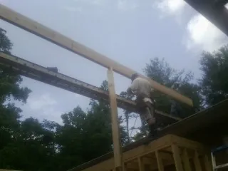 Carpenter setting a ridge beam over a new addition frame — Ice Dam Removal by Roofing Brothers in Villa Park