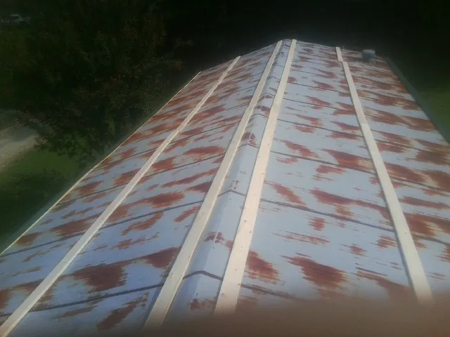 Rusted metal roof panels with new wood purlins before replacement — Storm Damage Roof Repair in Villa Park by Roofing Brothers