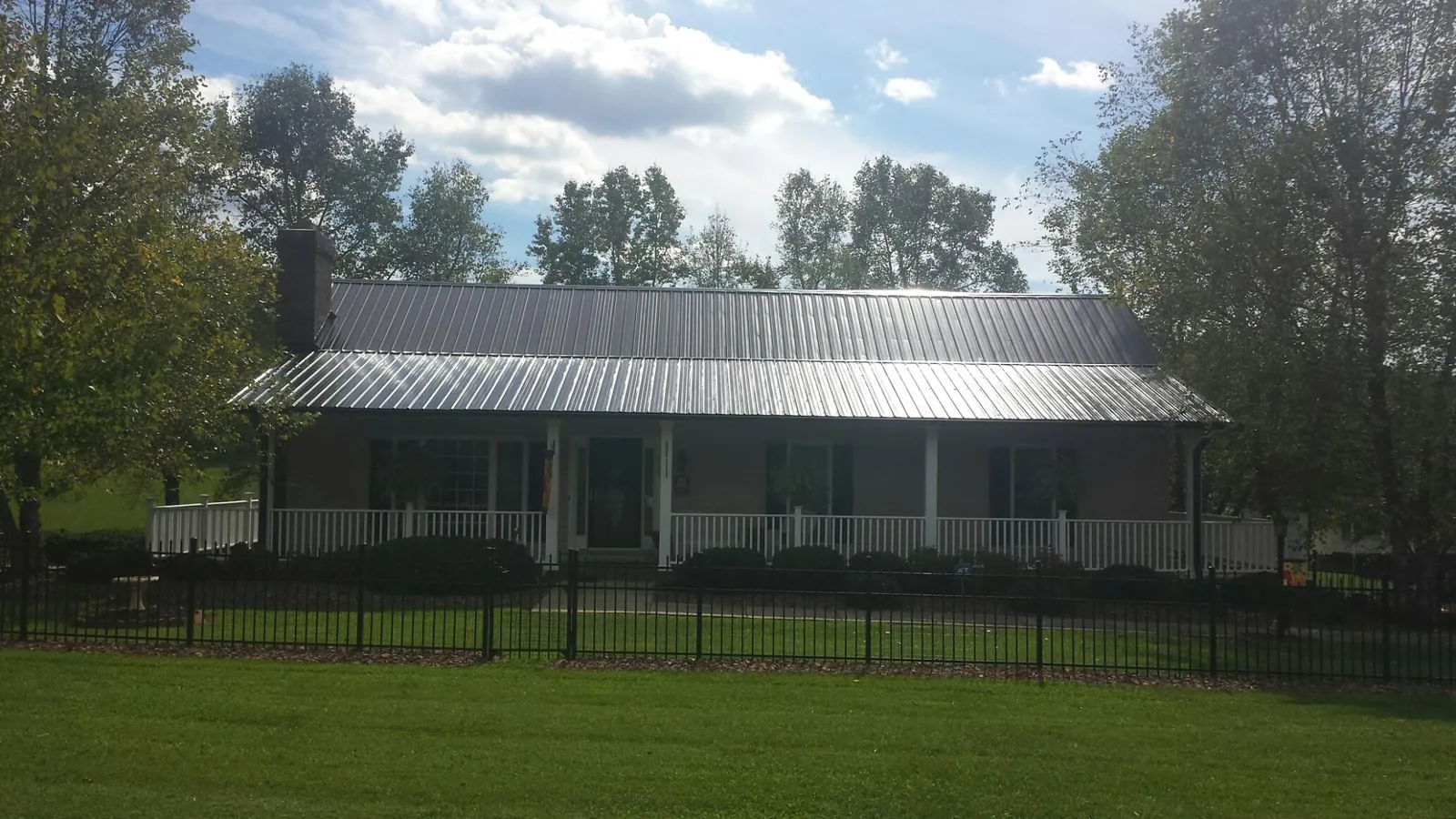 Gray metal roof on a brick ranch with a full width front porch — Gutter Guard Installation work by our crew in Villa Park